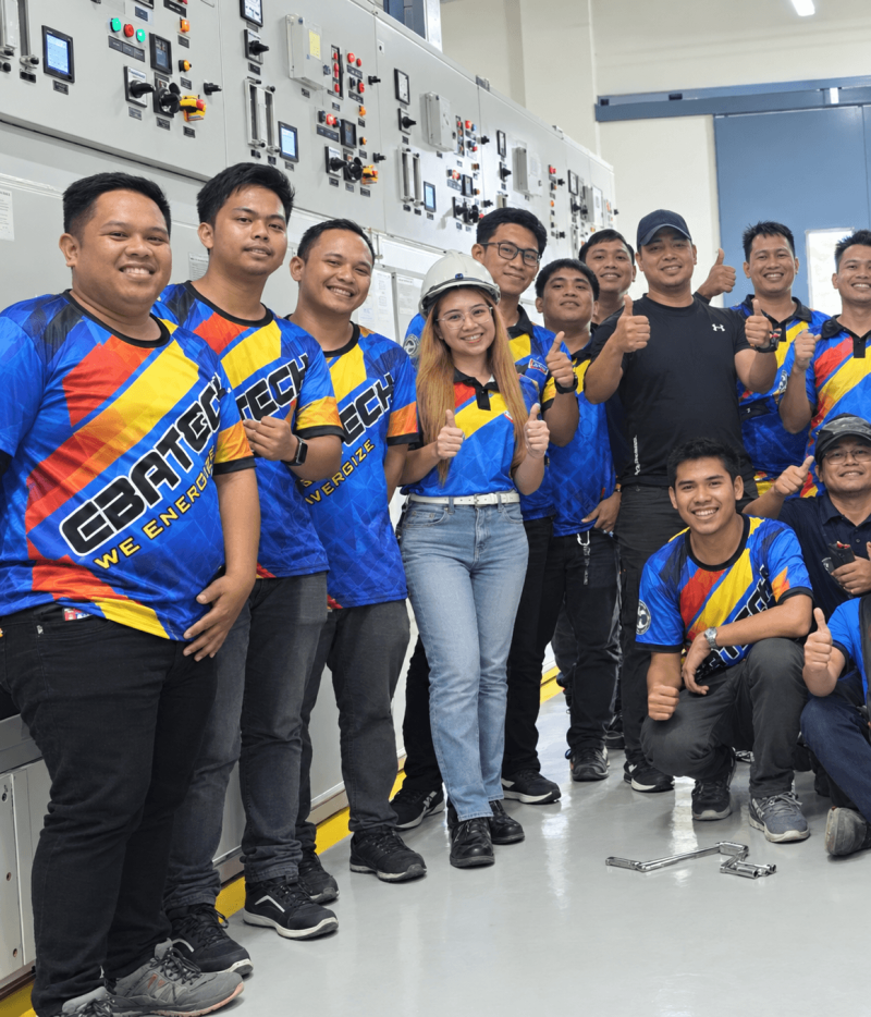 The EBAX team giving a thumbs-up in front of switchgear panels